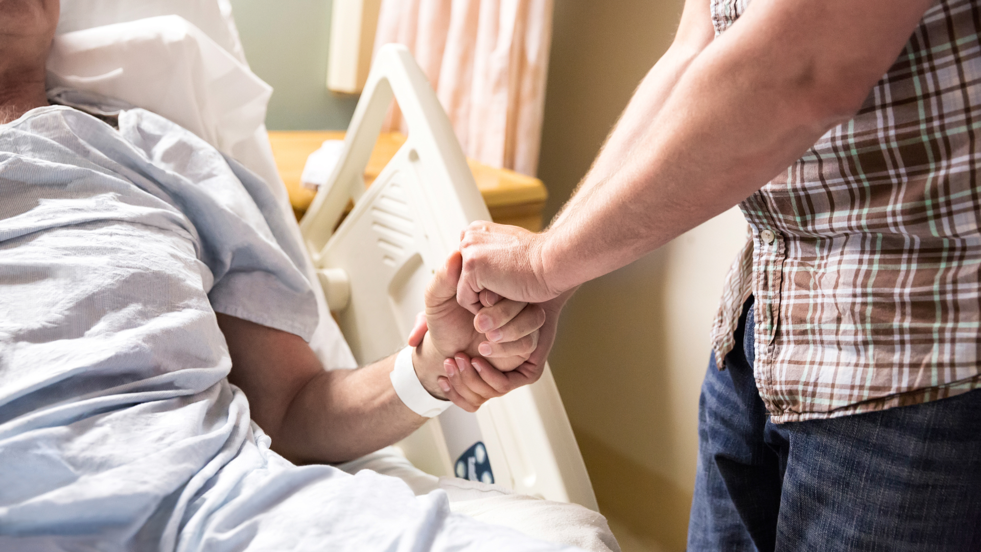 Two people holding hands in hospital