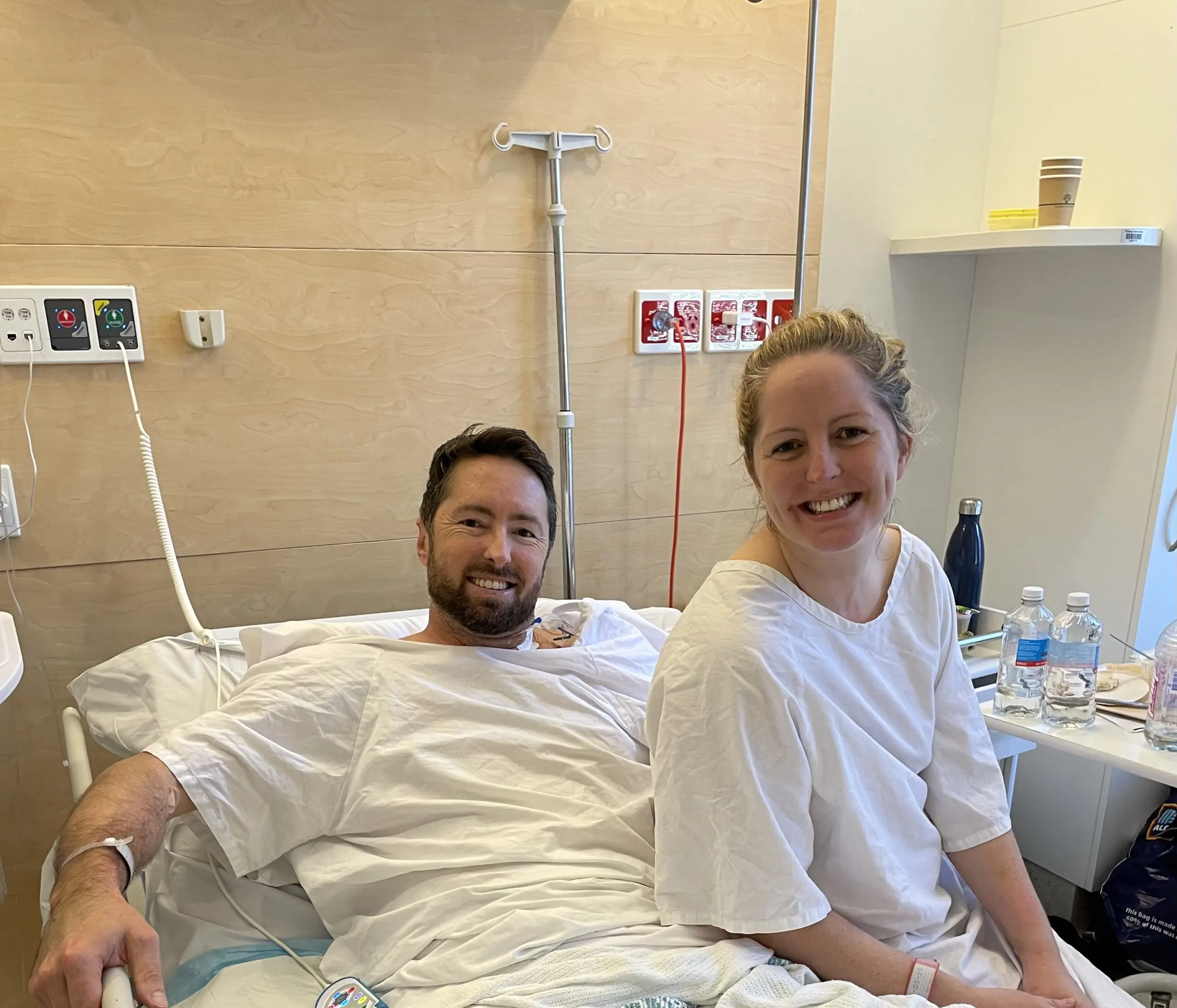 Man and woman on hospital bed smiling