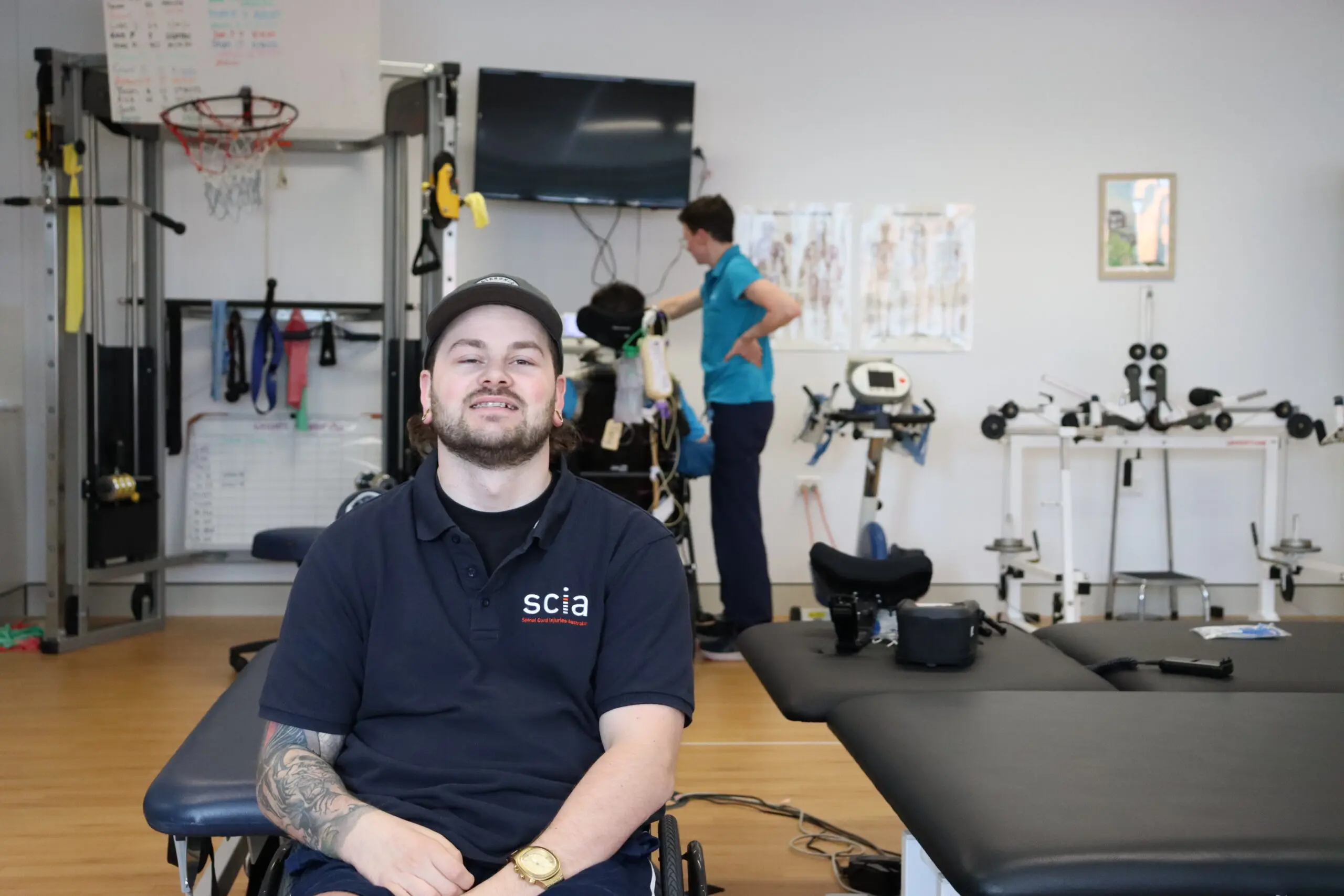 Young main in wheelchair at physio after spinal cord injury