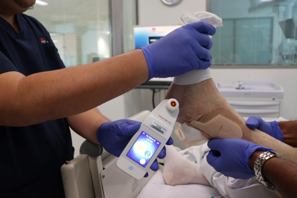 A small medical device next to a foot