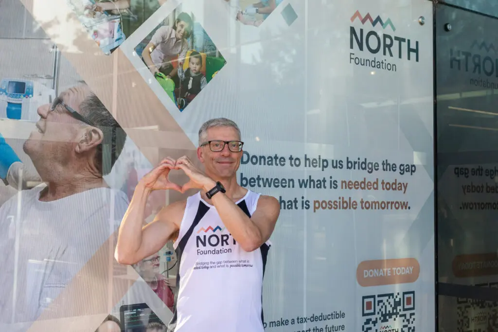 Man in front of NORTH Foundation banner