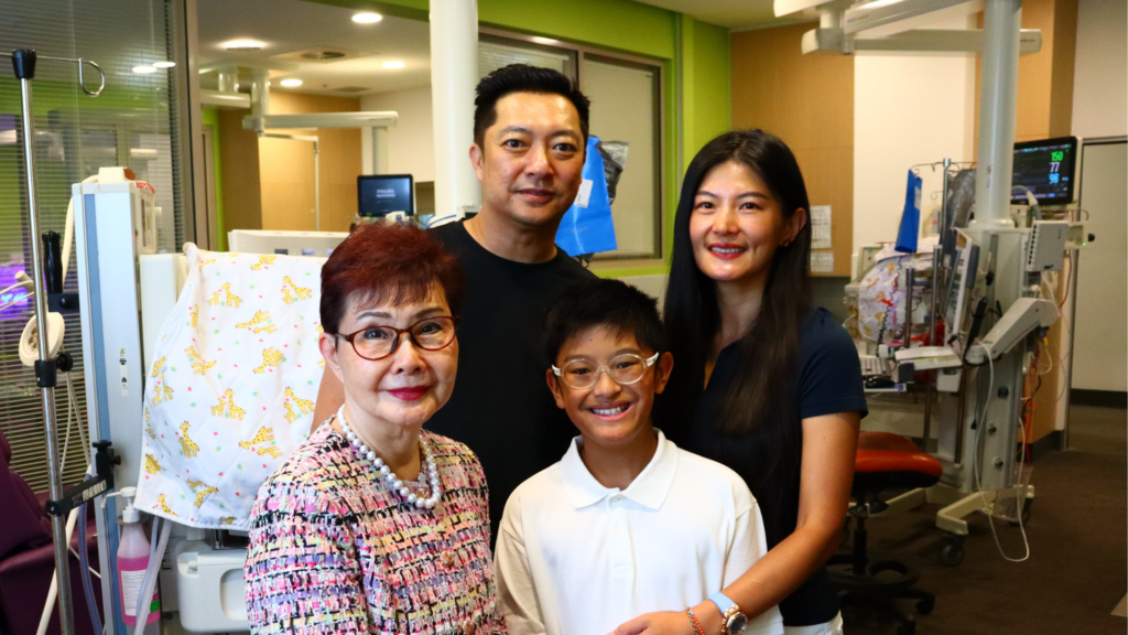 The Chan family in front of a Giraffe OmniBed Carestation in NICU