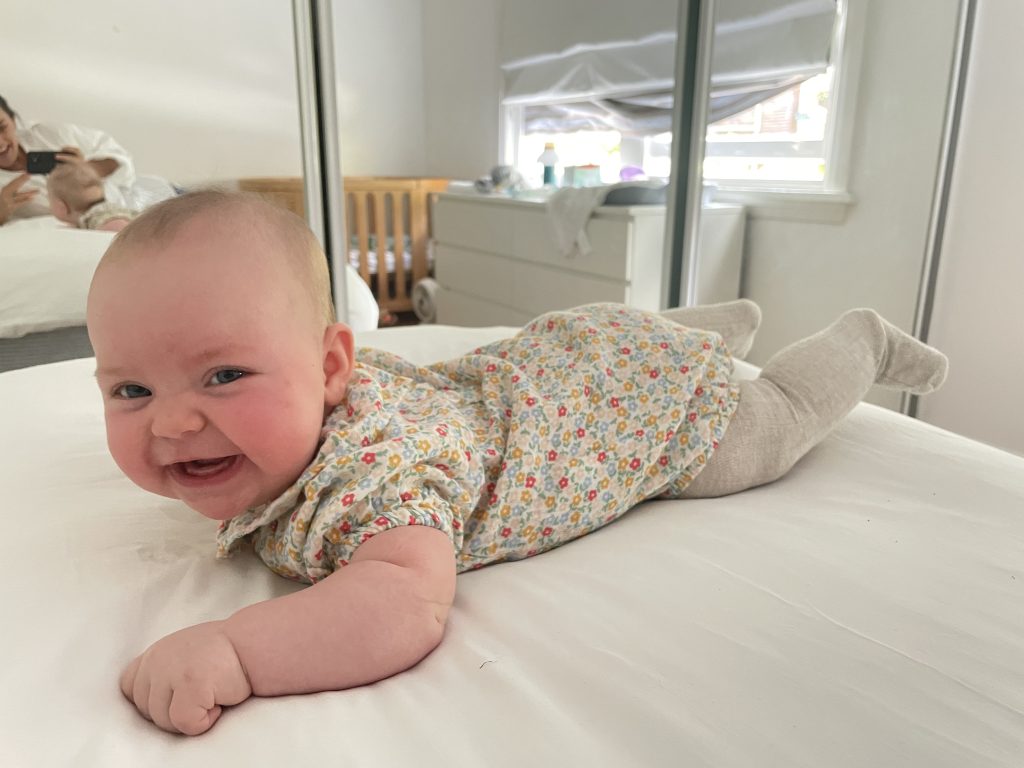Baby Florence smiling on a bed