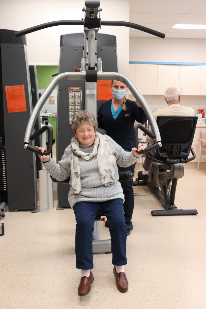 Smiling woman on an exercise equipment working on her frailty