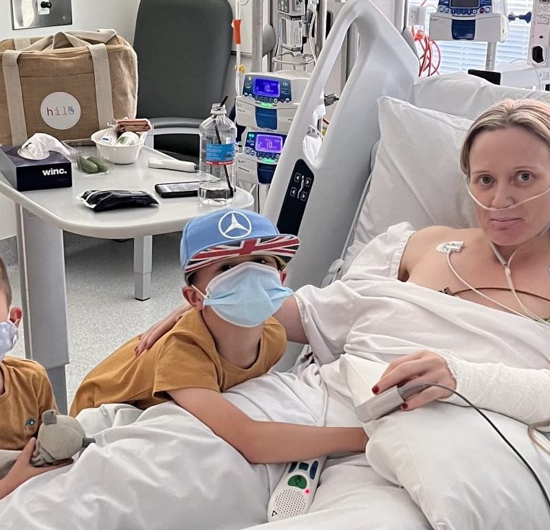 Woman in hospital bed with her two young boys