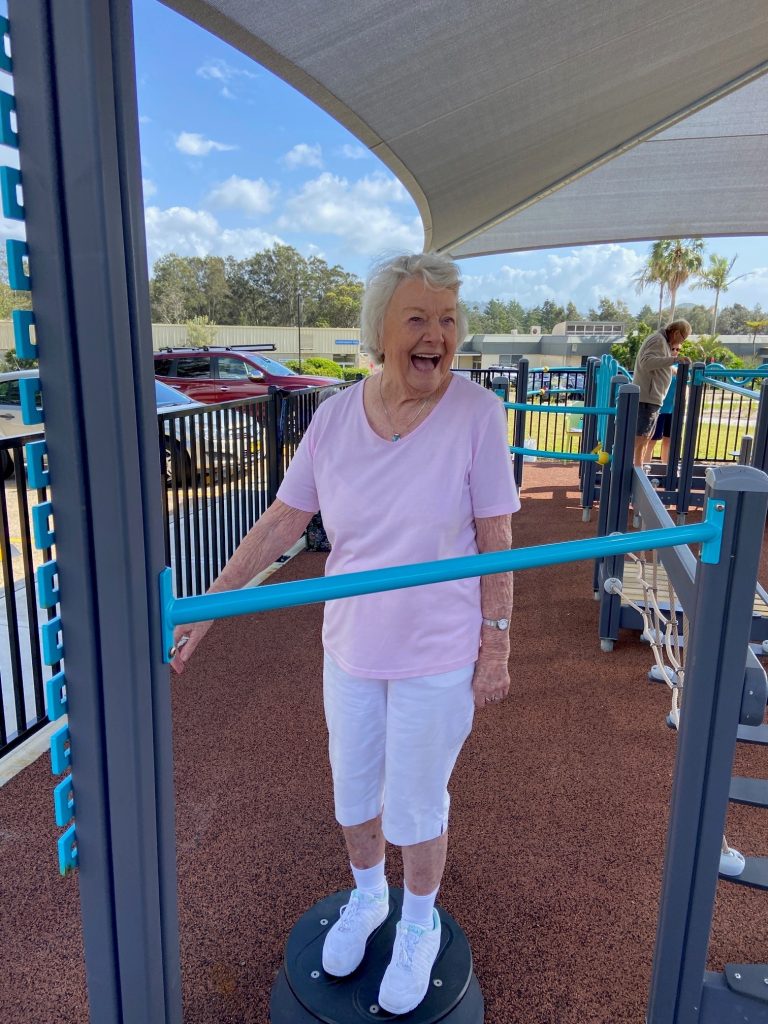Senior woman laughing in outdoor gym