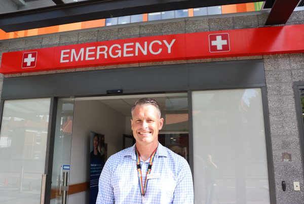 Man standing under an emergency sign