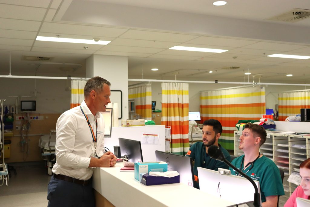 Three men talking around a desk