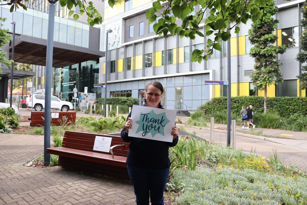 Female holding a Thank you sin in from on Royal North Shore Hospital