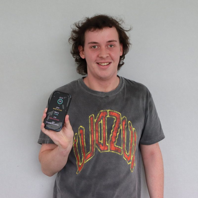 Young man holding a mobile phone showing his diabetes management app