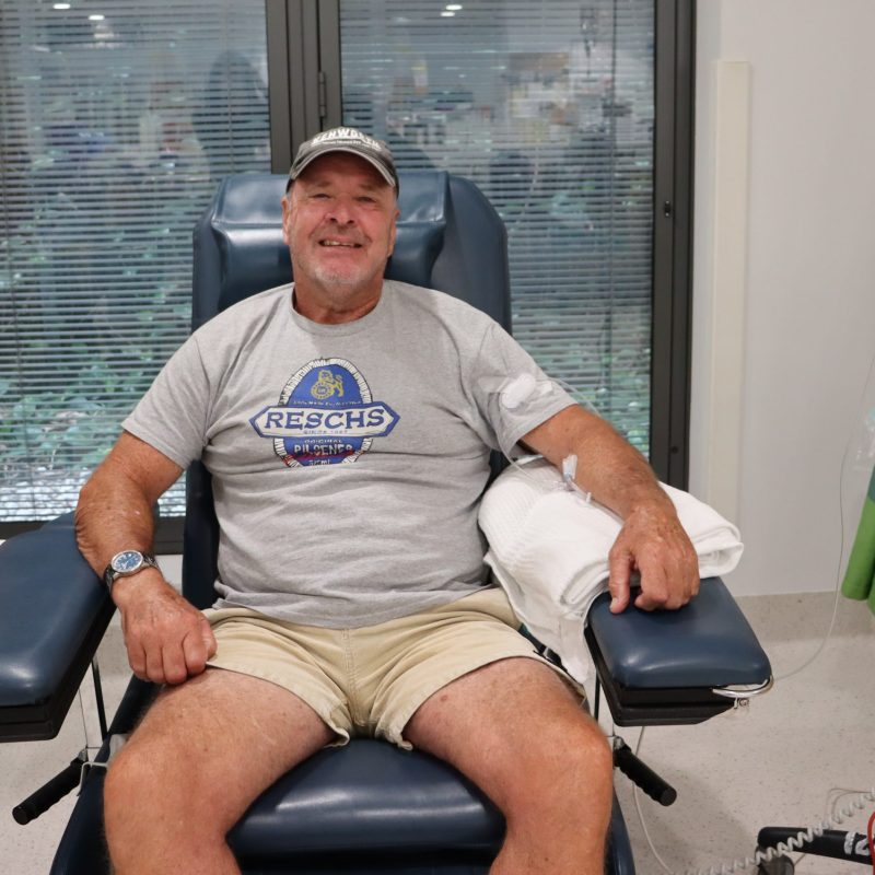 A man in a hospital chair smiling