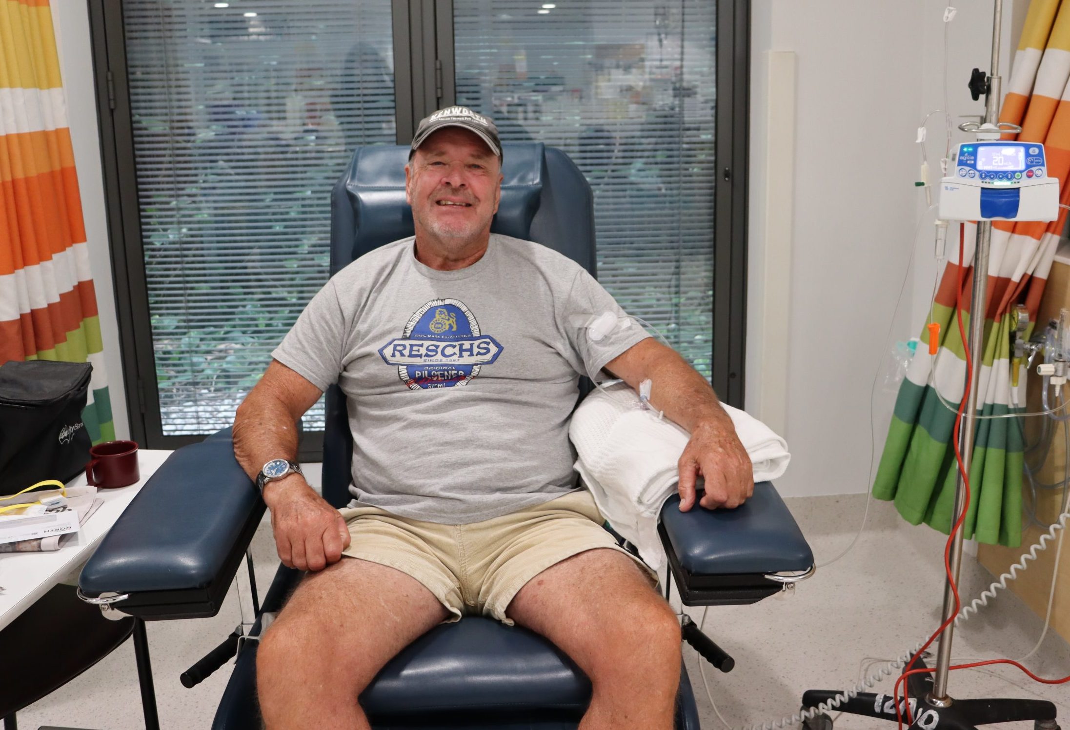 A man in a hospital chair smiling