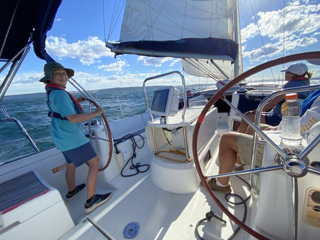 Young boy at the steering wheel of a yacht