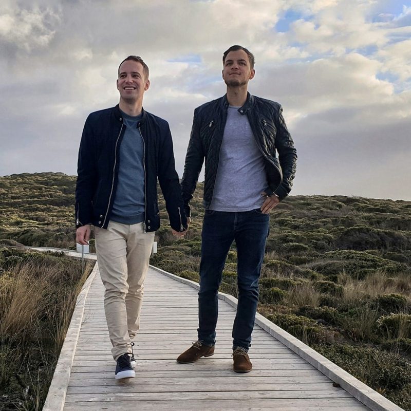 Two man holding hands on a boardwalk