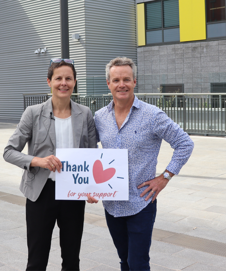Pf Gemma Figtree with male patient holding a thank you sign