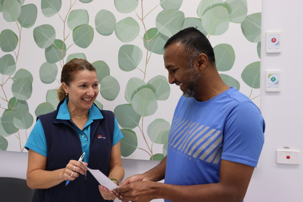 Christine presenting Vivek with his graduation certificate