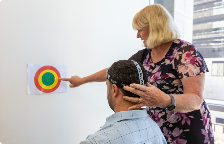 Woman assessing male patient after concussion